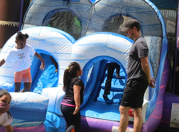 A group of people standing around an inflatable slide.